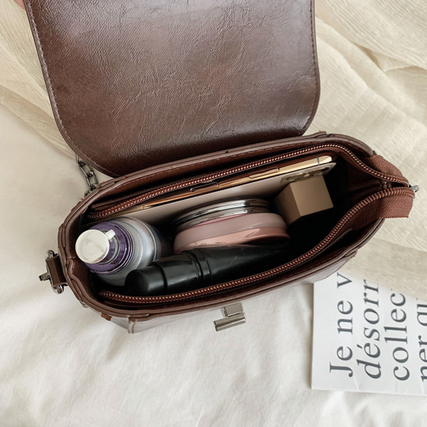 Ādas soma ar metāla aizdari un garu rokturi