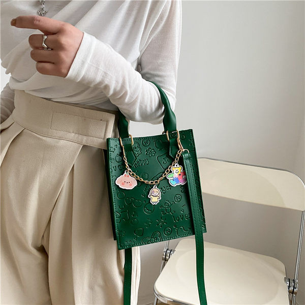 Σύγχρονη γυναικεία τσάντα με μεταλλική αλυσίδα και αξεσουάρ