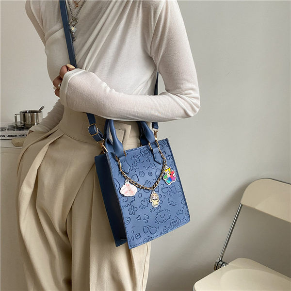 Σύγχρονη γυναικεία τσάντα με μεταλλική αλυσίδα και αξεσουάρ