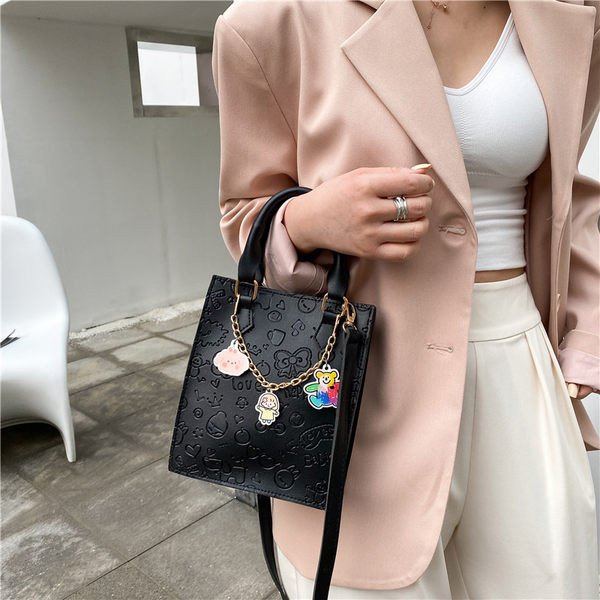 Σύγχρονη γυναικεία τσάντα με μεταλλική αλυσίδα και αξεσουάρ