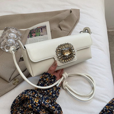 Maza taisnstūra soma, kas dekorēta ar akmeņiem un garu rokturi