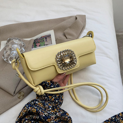 Maza taisnstūra soma, kas dekorēta ar akmeņiem un garu rokturi