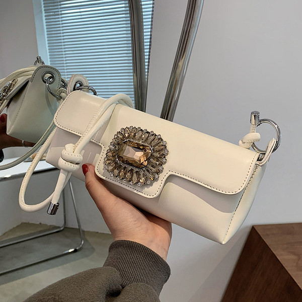 Maza taisnstūra soma, kas dekorēta ar akmeņiem un garu rokturi