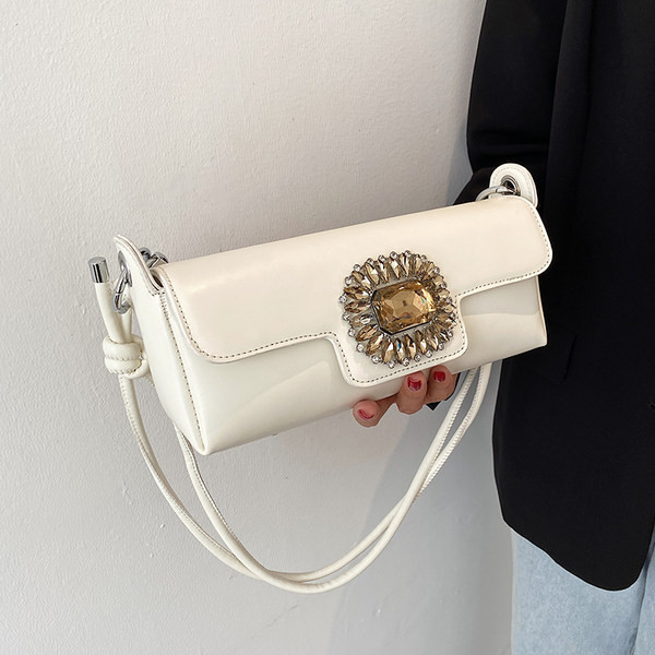 Maza taisnstūra soma, kas dekorēta ar akmeņiem un garu rokturi