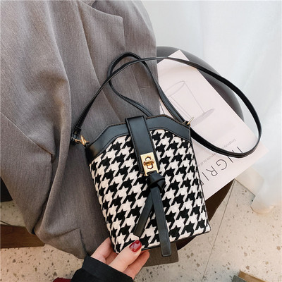 Κομψή μικρή τσάντα με μεταλλική πόρπη και μακριά λαβή