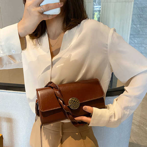 Σύγχρονη γυναικεία τσάντα με πλεκτή δερμάτινη λαβή και μεταλλική στερέωση