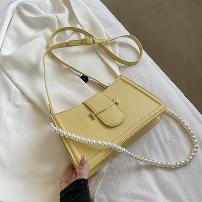 Γυναικεία τσάντα με μεταλλικό στοιχείο και πέρλες στη λαβή