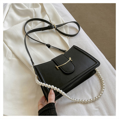 Γυναικεία τσάντα με μεταλλικό στοιχείο και πέρλες στη λαβή