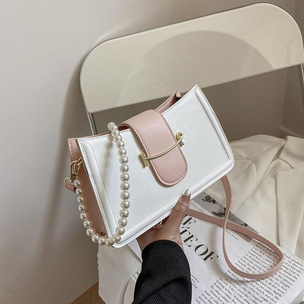 Γυναικεία τσάντα με μεταλλικό στοιχείο και πέρλες στη λαβή