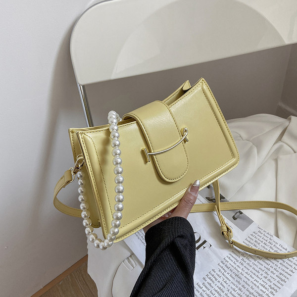 Γυναικεία τσάντα με μεταλλικό στοιχείο και πέρλες στη λαβή