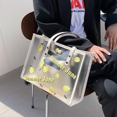 Caurspīdīga sieviešu ādas soma ar aplikāciju un uzrakstu