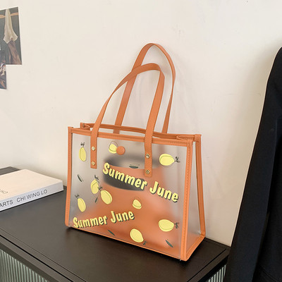 Caurspīdīga sieviešu ādas soma ar aplikāciju un uzrakstu