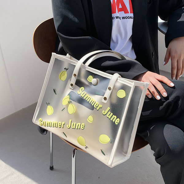 Caurspīdīga sieviešu ādas soma ar aplikāciju un uzrakstu