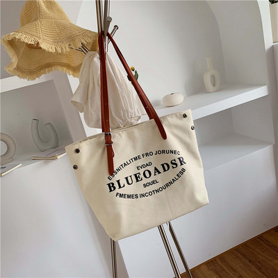 Liela tekstila soma ar eko ādas rokturiem un uzrakstiem