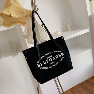 Liela tekstila soma ar eko ādas rokturiem un uzrakstiem