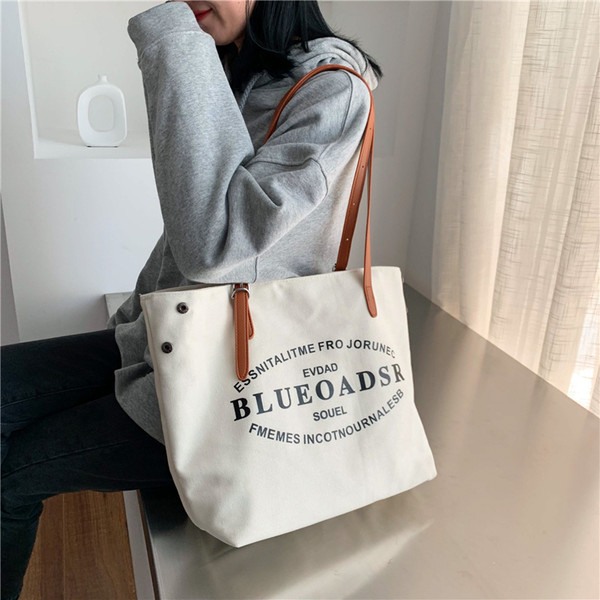 Liela tekstila soma ar eko ādas rokturiem un uzrakstiem