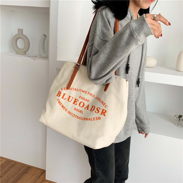 Liela tekstila soma ar eko ādas rokturiem un uzrakstiem