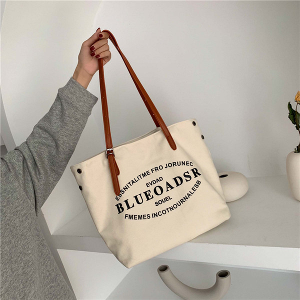 Liela tekstila soma ar eko ādas rokturiem un uzrakstiem