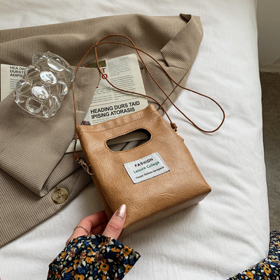 Γυναικεία δερμάτινη τσάντα με έμβλημα και μακριά λαβή