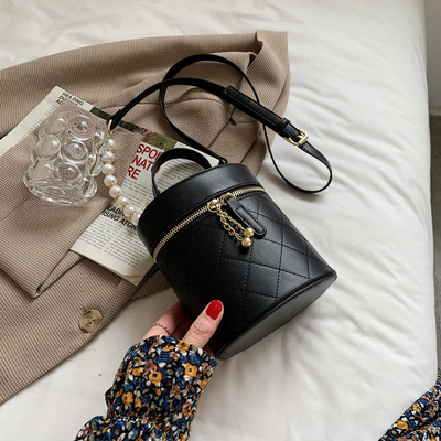 Γυναικεία τσάντα σε στρογγυλό σχήμα με μεταλλικά στοιχεία