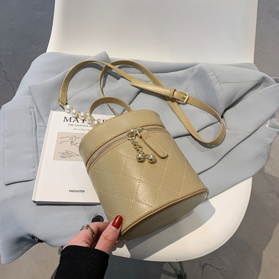 Γυναικεία τσάντα σε στρογγυλό σχήμα με μεταλλικά στοιχεία