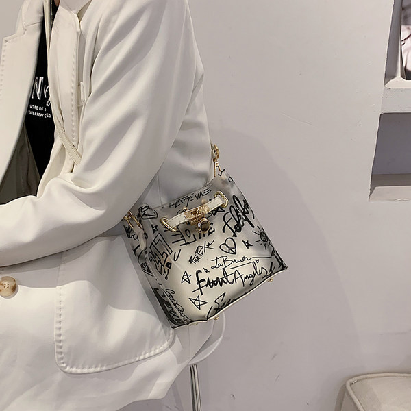 Γυναικεία τσάντα με δερμάτινη λαβή και μεταλλική διακόσμηση