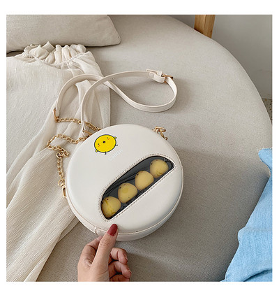 Moderna apaļa soma ar aplikāciju un garu rokturi