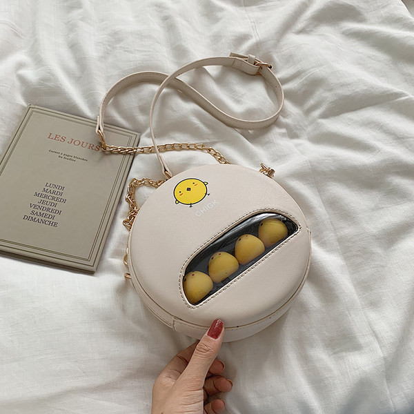 Moderna apaļa soma ar aplikāciju un garu rokturi