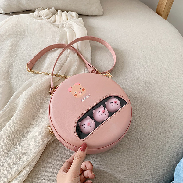 Moderna apaļa soma ar aplikāciju un garu rokturi