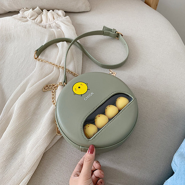 Moderna apaļa soma ar aplikāciju un garu rokturi