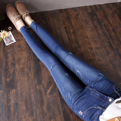 Sieviešu džinsi ar augstu vidukli un emblēmu kabatā