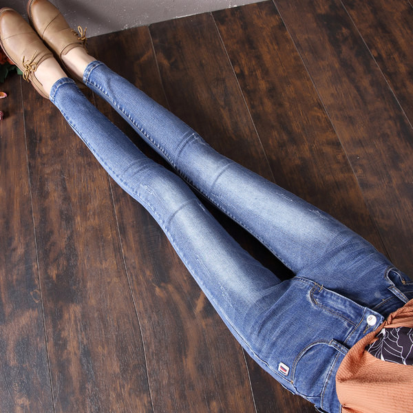 Sieviešu džinsi ar augstu vidukli un emblēmu kabatā