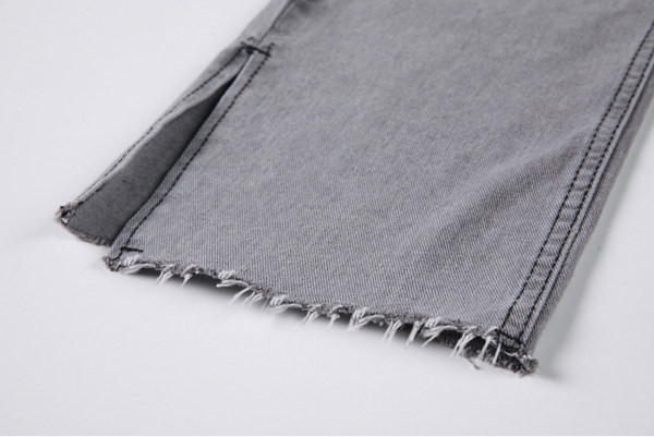 Sieviešu moderni džinsi ar šķēlumiem un saplēstu rakstu