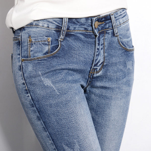 Sieviešu džinsi ar zemu vidukli un saplēstiem motīviem