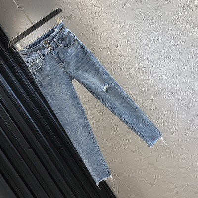 Sieviešu džinsi ar saplēstu motīvu un pogām zilā krāsā