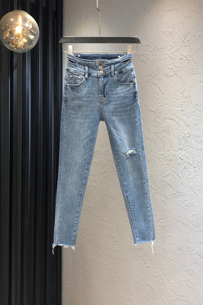 Sieviešu džinsi ar saplēstu motīvu un pogām zilā krāsā