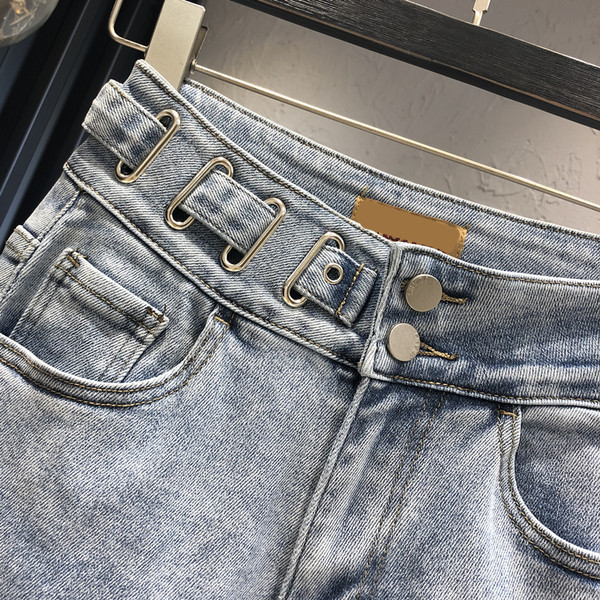 Sieviešu džinsi ar saplēstu motīvu un pogām zilā krāsā