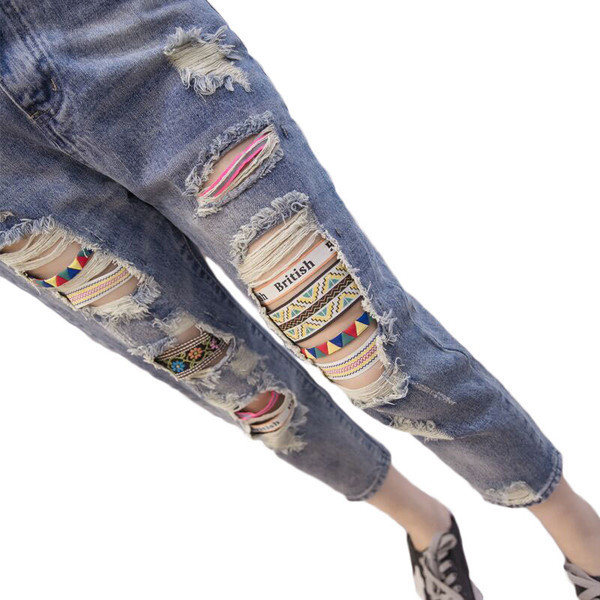 Sieviešu džinsi ar augstu vidukli un izšuvumiem saplēstiem motīviem