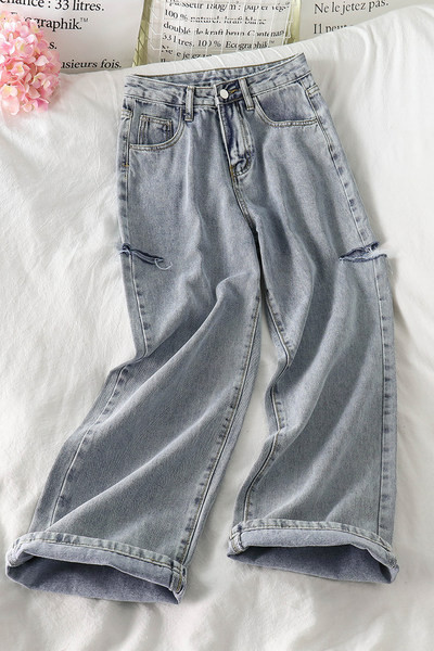 Sieviešu džinsu plats modelis ar saplēstiem motīviem