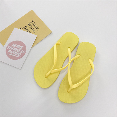 Krāsainas sieviešu flip-flops pār pirkstu ar dažādām aplikācijām