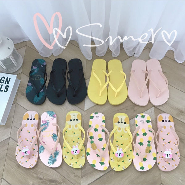 Krāsainas sieviešu flip-flops pār pirkstu ar dažādām aplikācijām