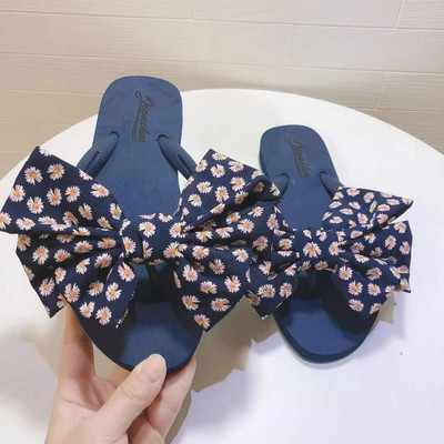 Sieviešu čības ar ziediem uz lentes un plakanu zoli