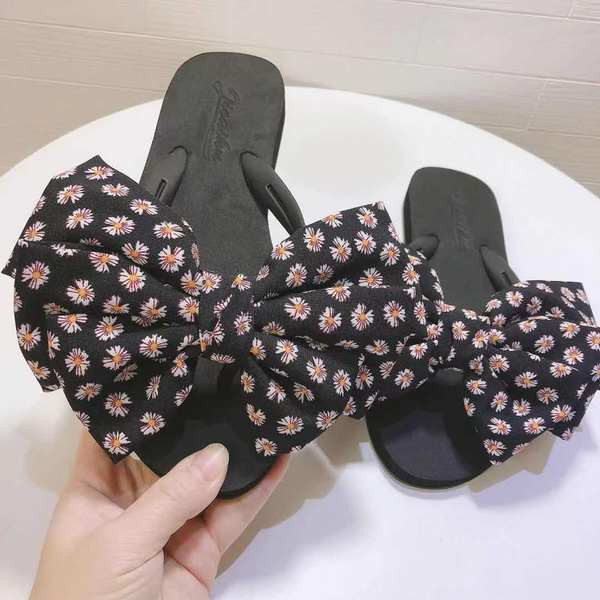 Sieviešu čības ar ziediem uz lentes un plakanu zoli