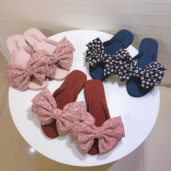 Sieviešu čības ar ziediem uz lentes un plakanu zoli