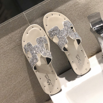 Jauns čību modelis ar plakanu zoli un siksnu ar spīdīgu efektu