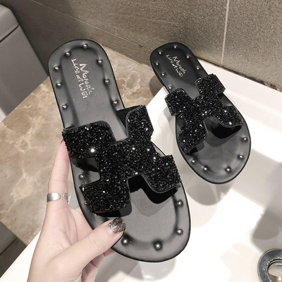 Jauns čību modelis ar plakanu zoli un siksnu ar spīdīgu efektu