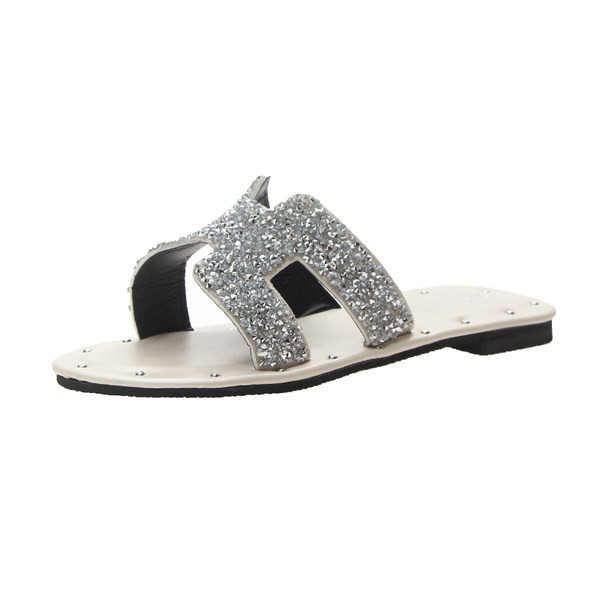 Jauns čību modelis ar plakanu zoli un siksnu ar spīdīgu efektu