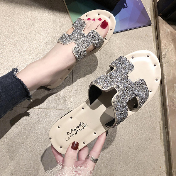 Jauns čību modelis ar plakanu zoli un siksnu ar spīdīgu efektu