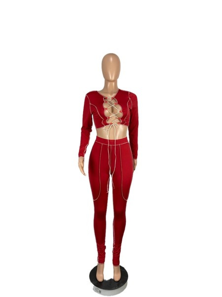 Aktualan ženski komplet iz dva dijela - hlače visokog struka i bluza s otvorenim dekolteom i vezicama