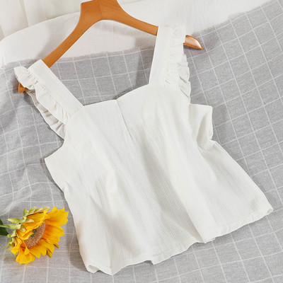 Ühevärviline naiste topp, mille rihmadel on lokid